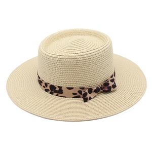 Detail of hand-woven straw hat with leopard print ribbon and elegant bow accent