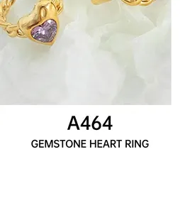 Dettaglio macro di un anello a catena d'oro intrecciato con gemma viola a forma di cuore