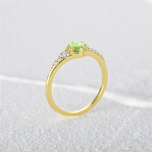 Detailed macro view of 925 silver gold-plated ring with round green zircon and side stones