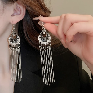 Detail of silver bamboo style earrings with long snake chain tassels and black enamel inlay