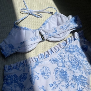 Detail of blue floral print bikini with underwire top and ruffled waist trimmings
