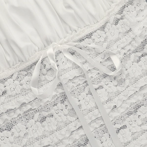 Close-up of white lace bodice detailing with satin ribbon tie and delicate floral patterns