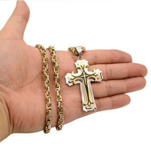 Detail of two-tone Byzantine chain and gold-silver cross pendant with black enamel