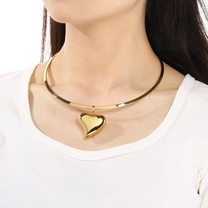 Detailed view of a polished 18K gold plated heart pendant on a smooth metal choker collar