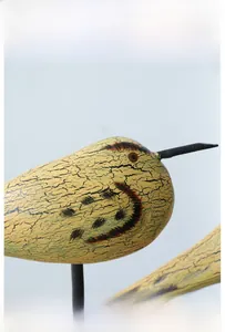 Detail view of hand-painted wooden bird sculpture with vintage crackle finish and textures