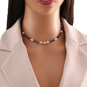 Natural stone beaded necklace with pearls and gold cubes on a model's neckline