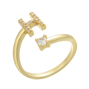 Detail of gold-plated open ring featuring a micro-paved letter H and a large round zircon