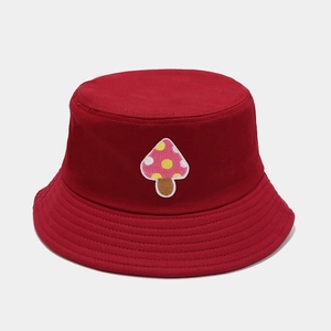 Close-up of mushroom embroidery and parallel stitching on a dark red cotton bucket hat