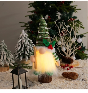 Dettaglio gnomo di Natale luminoso con LED e cappello a righe su una scena innevata festiva