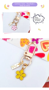 Detail of handmade metal flower keychains with yellow and pink enamel pendants