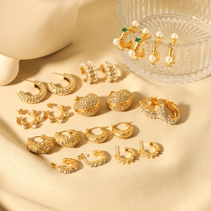 Luxurious 18K gold plated earring collection with pearls and rhinestones on beige fabric