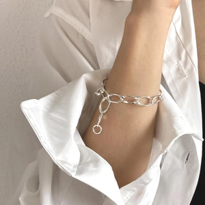Detailed close-up of 925 silver large link bracelet with round charm on wrist