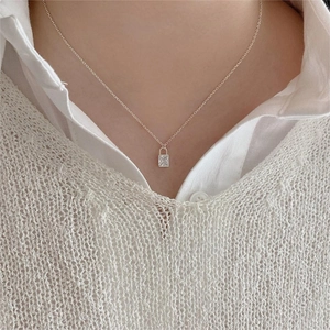 Detail view of 925 sterling silver padlock necklace with square zircon on a model