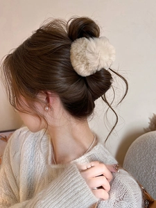Gros plan sur une pince à cheveux en peluche beige portée pour un look d'hiver douillet