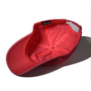 Detail of red cotton baseball cap interior showing 100% cotton label and stitching