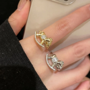 Detail of gold and silver rocking horse rings with pavé zircon stones on hand