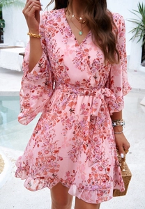 Close-up of pink floral chiffon dress with V-neckline and ruffled hem detail