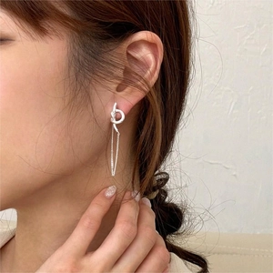 Elegant 925 sterling silver knot tassel drop earrings worn by a model on a beige background