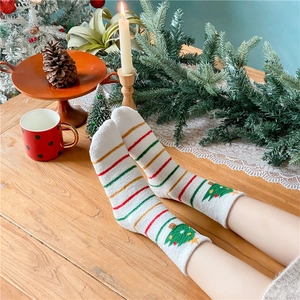 Détail de chaussettes de Noël en polaire corail avec rayures et broderie festive