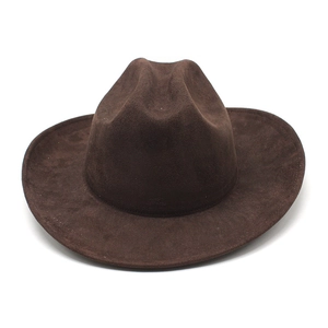 Macro detail of dark brown faux suede texture and classic crown crease on western cowboy hat