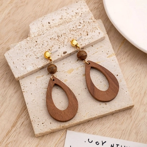 Retro geometric hollow teardrop wood earrings on stone background for women