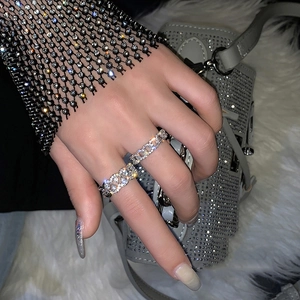 Luxury silver chain rings with sparkling crystals worn over a stylish grey studded handbag