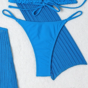 Detail of blue bikini bottoms with matching wave knit hollow cover-up on white background