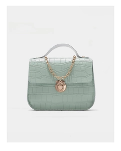 Detail of mint green crocodile embossed mini bag with gold chain and metal clasp