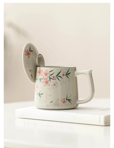 Detailed view of hand-painted plum blossom and bamboo on Chinese ceramic mug with lid