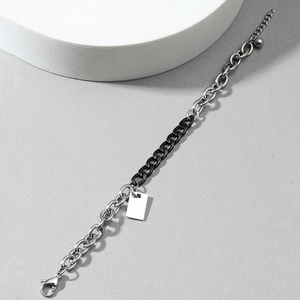 Two-tone stainless steel bracelet with silver rings and black flat links on grey background