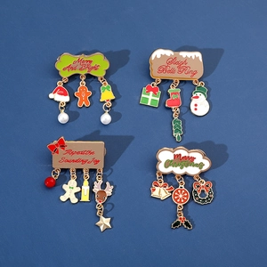 Detail of four Christmas enamel brooches with holiday phrases and pearl charms