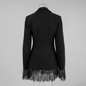 Detail view of the back of a black blazer with delicate lace hem and tailored waist