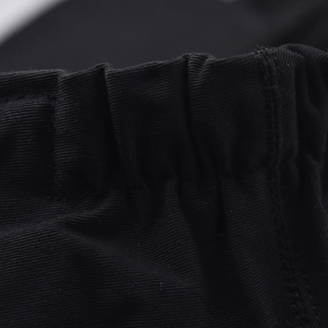 Detail of black beret cap featuring elastic waist design and twill cotton fabric texture