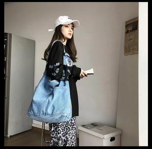 Detailed view of spacious washed blue denim tote bag with wide shoulder strap