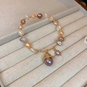 Detail of freshwater pearl bracelet with lucky cat charm in a beige velvet jewelry box