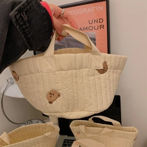 Quilted beige storage bag with cute brown bear embroidery and a webbing handle