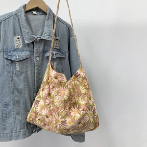 Close-up of floral canvas tote bag with pink and yellow flower patterns on a denim jacket