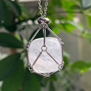 Detailed macro of a raw crystal stone encased in a silver mesh cage necklace pendant