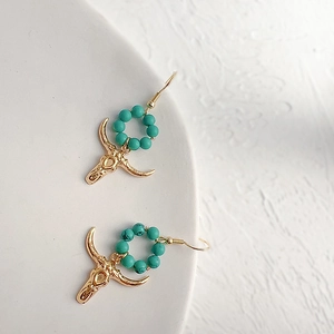 Bohemian gold bull skull earrings with turquoise beads in a vintage ethnic style