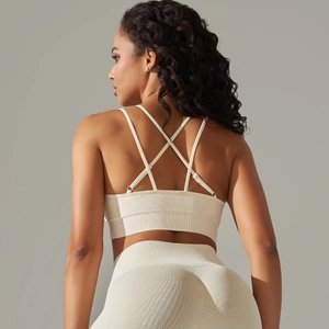 Detail of cross-strap back design on seamless cream sports bra and high-waist yoga leggings