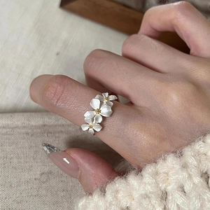 Macro shot of 925 silver flower ring with white matte finish and golden details