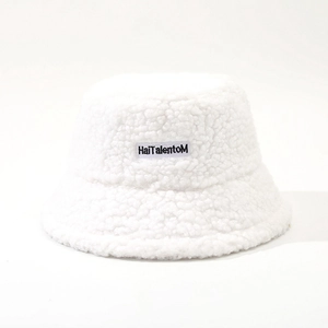 Detailed view of the soft white faux shearling fabric and the embroidered logo patch on the hat