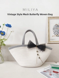 Detail of hand-woven cotton rope handbag featuring a black mesh bow and delicate pearl chain
