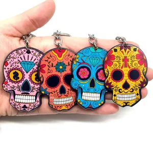 Set of four colorful acrylic sugar skull keychains with floral Mexican Day of the Dead patterns