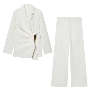Detail of white blazer set featuring golden buckle accent and refined suit texture