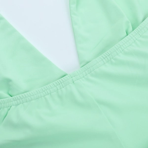 Gros plan sur la double couture d'une robe dos nu vert menthe montrant la texture du tissu