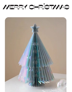 Close-up of holographic paper Christmas tree with laser iridescent finish and cut-out stars