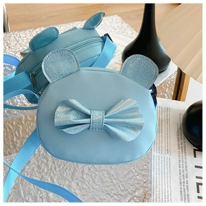 Close-up of light blue kids crossbody bag with 3D animal ears and glittery bow detail