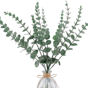 Artificial green eucalyptus stems in a transparent glass vase with twine bow decoration