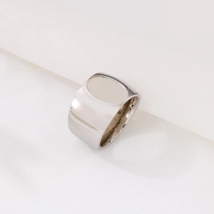 Polished silver stainless steel wide signet ring for men on white textured background